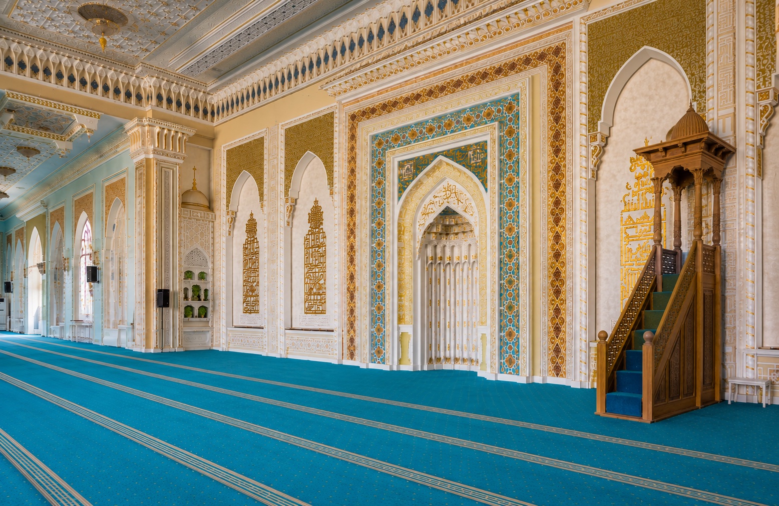 Interior of a mosque prayer hall with a carved wooden minbar